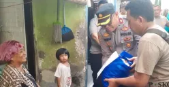 Kapolsek Beji Kompol Josman Harianja blusukan bersama anggota membagikan bantuan paket sembako ke warga ibu-ibu yang tinggal di dalam gang sempit Kelurahan Beji, Kota Depok, langsung tersenyum bahagia. (Sumber: Poskota/Angga Pahlevi)