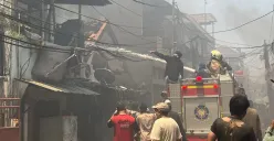 Petugas pemadam kebakaran hingga warga berupaya memadamkan api kebakaran rumah di Gang Langgar 1 RW 06, Kelurahan Tangki, Kecamatan Tamansari, Jakarta Barat, Minggu, 28 September 2025. (Sumber: Poskota/Pandi Ramedhan)