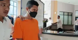 Ustaz cabul, Masturo Rohili, 52 tahun, digiring personel Polres Metro Bekasi seusai ditetapkan sebagai tersangka kasus pelecehan anak angkat dan keponakannya, Senin, 29 September 2025. (Sumber: Poskota/Nurpini Aulia Rapika)