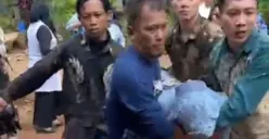 Sejumlah warga membopong istri korban Dadang yang pingsan setelah mengetahui suaminya jatuh dihantam balok kayu oleh preman kampung. (Sumber: Istimewa)