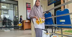 Warga Serua, Nokyani, ibu rumah tangga sangat senang mendapatkan bantuan pangan pemerintah diambil sendiri di kantor Kelurahan Serua. (Sumber: Poskota/Angga Pahlevi)
