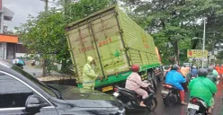 Sebuah truk terperosok ke saluran air di Jalan Puri Kembangan, Cengkareng, Jakarta Barat (Jakbar), Jumat, 20 Februari 2026. (Sumber: X/@TMCPoldaMetro)