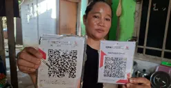 Warga Bedahan, Sawangan, Kota Depok, menunjukan QRIS palsu yang ditimpa pada kode QR asli, Rabu, 25 Februari 2026. (Sumber: Poskota/Angga Pahlevi)