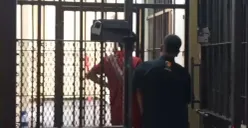 Kenakan baju orange, seorang Kades di Pandeglang saat dimasukan ke sel tahanan Polres Pandeglang. (Sumber: Poskota/Samsul Fatoni)