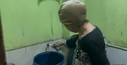 Salah satu warga di Kelurahan Jembatan Besi, Kecamatan Tambora, Jakarta Barat, yang sedang menyalakam kran yang airnya tidak keluar, Jumat, 9 Januari 2026. (Sumber: Poskota/Pandi Ramedhan)