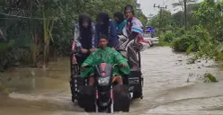 Pelaku jasa ojek tosa di Pagelaran, Pandeglang, saat mengangkut warga di tengah banjir merendam jalan raya. (Sumber: Poskota/Samsul Fatoni)