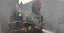 Petugas Damkar Bandung Barat melakukan pendinginan kios sandal di Kecamatan Cihampelas, Kabupaten Bandung Barat, Senin, 19 Januari 2026. (Sumber: Poskota/Gatot Poedji Utomo)