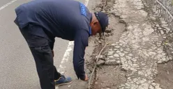 Petugas teknisi PJU Dinas Perhubungan Kota Depok sedang memperbaiki kabel tanam PJU di Jalan Raya Bogor, konslet hingga mengeluarkan asap putih. (Sumber: Dok. Polsek Cimanggis)