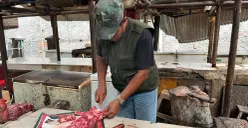 Pedagang daging sapi di Pasar Cakung, Jakarta Timur, Suryadi mencincang barang jualannya, Kamis, 22 Januari 2026. (Sumber: Poskota/M. Tegar Jihad)