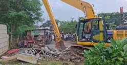 Alat berat jenis beko membongkar pagar pembatas yang dibangun di kawasan bibir Setu Tujuh Muara, Sawangan, Kota Depok. (Sumber: Poskota/Angga Pahlevi)