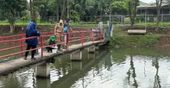 Petugas DLH Kabupaten Bogor memeriksa kadar air di Situ Citongtut seusai ribuan ikan mati mendadak, Senin, 26 Januari 2026. (Sumber: Poskota/Giffar Rivana)
