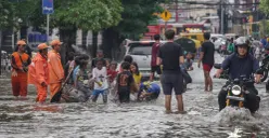 Warga melintasi genagan banjir di Jalan Bendungan Hilir, Jakarta Selatan, Minggu, 8 Maret 2026. (Sumber: Poskota/Bilal Nugraha Ginanjar)