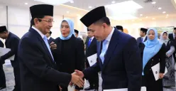 Menag Nasaruddin Umar menyerahkan Keppres Penetapan Anggota BAZNAS kepada Dirjen Bina Keuda Agus Fatoni. (Sumber: Dok. Puspen Kemendagri)