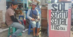 Yanto, 64 tahun, tukang reparasi sol sepatu, melayani pelanggan di lapaknya, Pasar Depok Lama, Jalan Dewi Sartika, Pancoran Mas, Kota Depok, Rabu, 11 Maret 2026. (Sumber: Poskota/Angga Pahlevi)