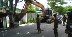 Anggota Satpol PP Kabupaten Tangerang membongkar bangunan liar di Jalan Raya Desa Keramat, Kecamatan Pakuhaji. (Sumber: Poskota/Veronica Prasetio)