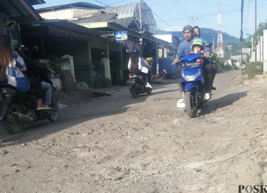 Pengendara motor melintasi jalan rusak di Jalan Raya Cibodas, Kecamatan Lembang, Kabupaten Bandung Barat. (Sumber: Poskota/Gatot Poedji Utomo)