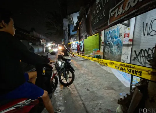 Warga melihat lokasi pembunuhan di Jalan Masjid Darussalam, Kelurahan Kedaung, Pamulang, Tangsel yang telah dipasang garis polisi, Rabu, 30 April 2025. (Sumber: Poskota/Angga Pahlevi)