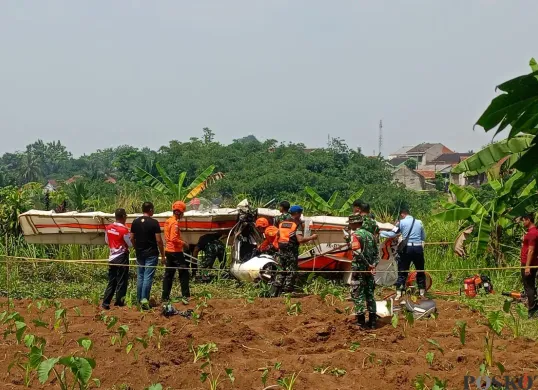 Bangkai pesawat yang terjatuh di dekat di dekat Tempat Pemakaman Umum (TPU), Kampung Astana RT 03/01, Desa Benteng, Kecamatan Ciampea, Kabupaten Bogor, Minggu, 3 Agustus 2025. (Sumber: Poskota/Giffar Rivana)