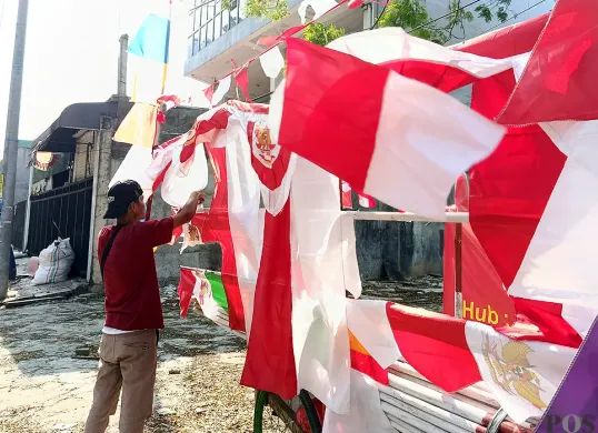 Didi Supriadi, 30 tahun, pria asal Cirebon, yang jualan bendera di sekitar Danau Duta Harapan, Bekasi Utara, Kota Bekasi. (Sumber: POSKOTA | Foto: Nurpini Aulia Rapika)