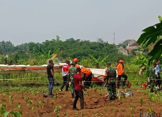Pesawat latih terjatuh di TPU Kampung Astana, Desa Benteng, Kecamatan Ciampea, Kabupaten Bogor, Minggu, 3 Agustus 2025. (Sumber: Poskota/Giffar Rivana)