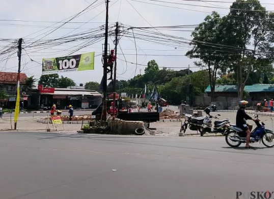 Petugas menurunkan kabel-kabel di Bunderan Jati, Jalan Rd. Demang Hardja Kusumah, Kota Cimahi, Selasa, 5 Agustus 2025. (Sumber: Poskota/Gatot Poedji Utomo)