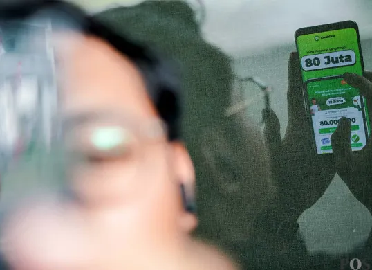 Warga menggunakan aplikasi pinjaman online di kawasan Blok M, Jakarta Selatan, Selasa, 5 Agustus 2025. (Sumber: POSKOTA | Foto: Bilal Nugraha Ginanjar)