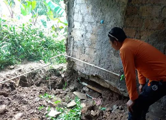 Petugas BPBD Kota Bogor mengecek kondisi rumah yang rusak akibat tanah ambles di Kampung Margabakti, Kelurahan Kertamaya, Kecamatan Bogor Selatan. (Sumber: Dok. BPBD Kota Bogor)