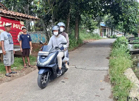Pengendara melintas di Jalan Enggram, Kelurahan Sawangan Baru, Kota Depok, Rabu, 6 Agustus 2025. (Sumber: POSKOTA | Foto: Angga Pahlevi)