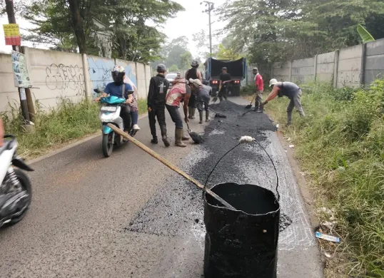 Petugas melakukan perbaikan jalan rusak di sejumlah titik di Kabupaten Bogor. Pemkab Bogor sendiri kini tengah gencar lakukan pemeliharaan jalan. (Sumber: Pemkab Bogor)