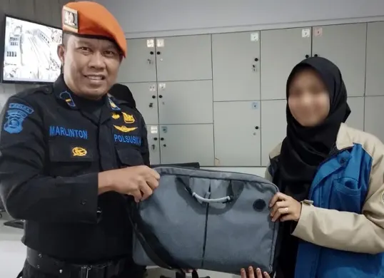 Petugas PT KAI menyerahkan laptop milik penumpang yang tertinggal di dalam kereta. (Sumber: Dok PT KAI Persero)