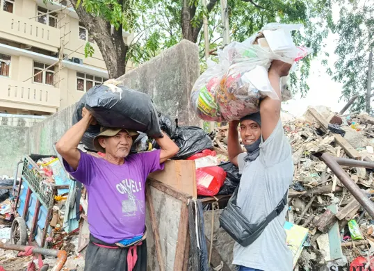 Maat (kanan), sudah 24 tahun berjuang menjadi petugas kebersihan di Kelurahan Pejuang, Kecamatan Medan Satria, Kota Bekasi. Di awal, ia mengaku hanya mendapatkan bayaran sebesar Rp150 ribu per bulan. (Sumber: Poskota/Nurpini Aulia Rapika)