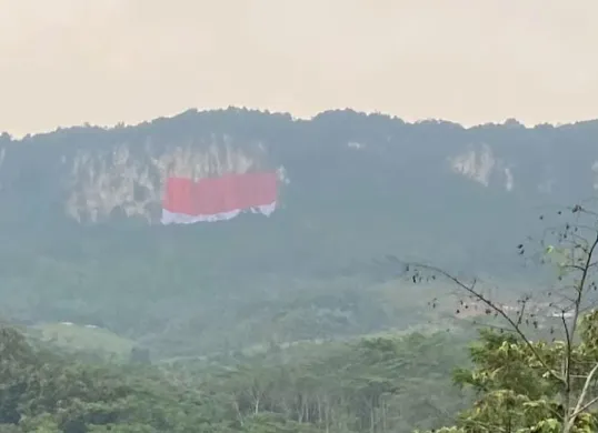 Pemasangan bendera merah putih berukuran 50x80 meter di Tebing Jeger, Klapanunggal, Kabupaten Bogor, memecahkan rekor MURI. (Sumber: Pemkab Bogor)