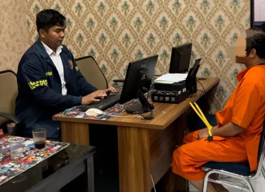 Tersangka IS alias Apih saat menjalani pemeriksaan di ruang Subdit Renakta Ditreskrimum Polda Banten. (Sumber: Polda Banten)