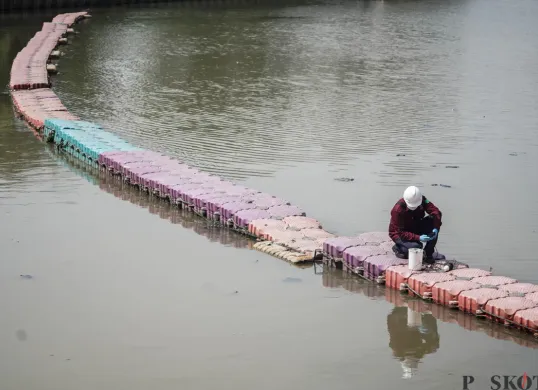 Petugas menyemprotkan air saat simulasi penanganan busa di Pintu Air Weir 3 Marunda, Kanal Banjir Timur (KBT), Jakarta Utara, Rabu, 13 Agustus 2025. (Sumber: Poskota/Bilal Nugraha Ginanjar)