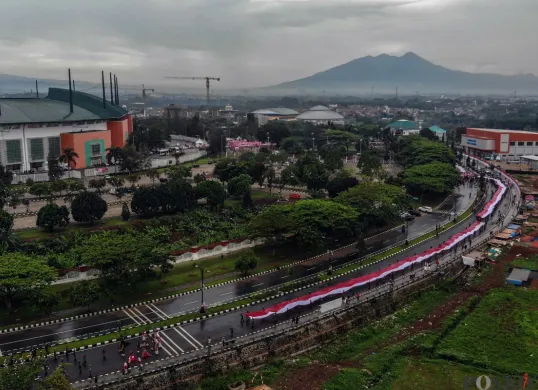 Kirab bendera merah putih sepanjang 600 meter dibawa dari Stadion Pakansari menuju Lapangan Tegar Beriman, Cibinong, Kabupaten Bogor, Kamis, 14 Agustus 2025. (Sumber: Poskota/Giffar Rivana)