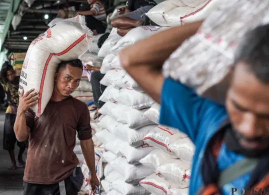 Buruh mengangkut beras di salah agen beras di Pasar Induk Beras Cipinang, Jakarta, Selasa, 12 Agustus, 2025. (Sumber: Poskota/Bilal Nugraha Ginanjar)