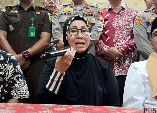 Putri Yeni alias Umi Cinta, ketua pengajian di Perumahan Dukuh Zamrud, yang diduga menyimpang menyampaikan keterangan kepada media seusai memenuhi panggilan MUI Kota Bekasi, Kamis, 14 Agustus 2025. (Sumber: POSKOTA | Foto: Nurpini Aulia Rapika)