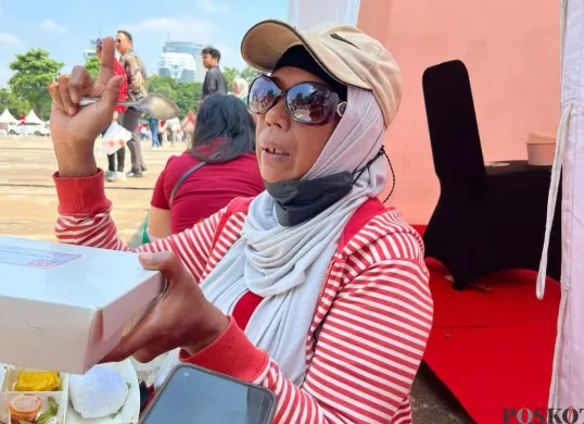 Sartika, 52 tahun, warga asal Tanggerang datang ke Monas, Jakarta Puat, untuk merasakan peringatan HUT ke-80 RI, Minggu, 17 Agustus 2025. (Sumber: Poskota/Muhammad Tegar Jihad)