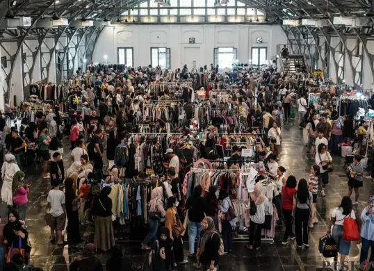 Pengunjung memilih pakaian yang dijual dalam acara Garage Sale di Pos Bloc, Jakarta, Minggu, 3 Agustus 2025. (Sumber: Poskota/Bilal Nugraha Ginanjar)