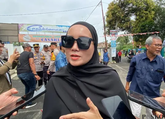 Orang tua murid, Hera 36 tahun, mengikuti aksi protes di depan gedung yayasan SDIT Raudlatul Jannah, Jalan Veteran III, Kecamatan Ciawi, Kabupaten Bogor, Selasa, 19 Agustus 2025. (Sumber: Poskota/Giffar Rivana)