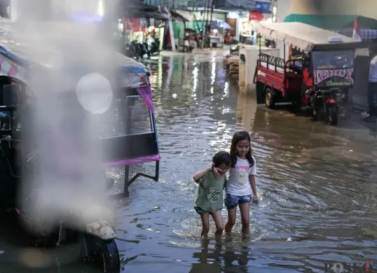 Ilustrasi - Warga melintasi genangan rob di Muara Angke, Jakarta Utara, Senin, 18 Agustus 2025. (Sumber: Poskota/Bilal Nugraha Ginanjar)