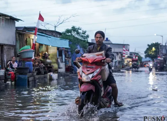 Ilustrasi - Warga melintasi genangan rob di Muara Angke, Jakarta Utara, Senin, 18 Agustus 2025. (Sumber: Poskota/Bilal Nugraha Ginanjar)