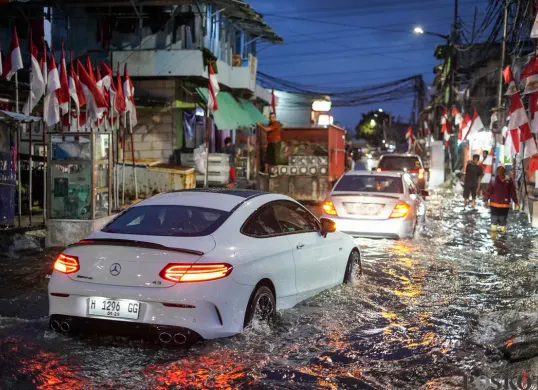 Warga melintasi genangan rob di Muara Angke, Jakarta Utara, Senin, 18 Agustus 2025. (Sumber: Poskota/Bilal Nugraha Ginanjar)