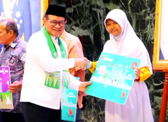 Potret Gubernur DKI Jakarta, Pramono Anung (kiri) yang memberikan secara simbolis kartu rekening untuk penerima baru bansos Kartu Anak Jakarta (KAJ). (Sumber: Dinas Sosial Pemprov DKI Jakarta)