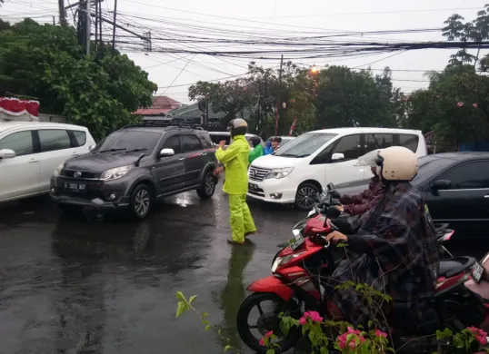 Ilustrasi - Polisi mengatur arus lalu lintas yang macet saat hujan deras. (Sumber: Polsek Cinere)
