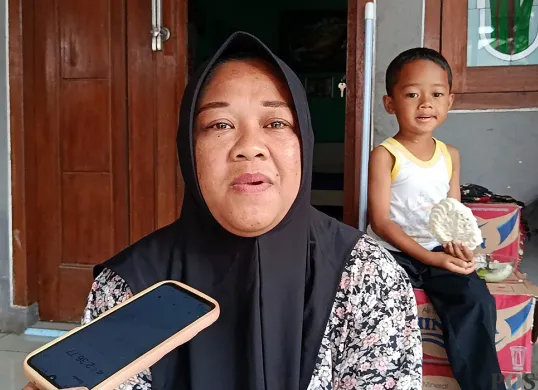 Ella, Ketua RT 06 Kampung Poponcol, Desa Pasirtanjung, Kecamatan Cikarang Pusat, Kabupaten Bekasi, saat memberikan keterangan kepada wartawan terkait teror ketuk pintu. (Sumber: POSKOTA | Foto: Nurpini Aulia Rapika)