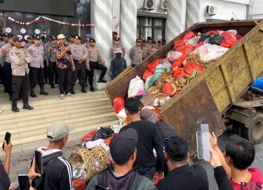 Pendemo saat menumpahkan sampah dari dump truk di depan Kantor Bupati Pandeglang pada Rabu, 20 Agustus 2025. (Sumber: POSKOTA | Foto: Samsul Fatoni)