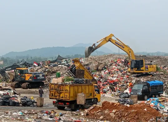 Alat berat menguruk gunungan sampah di TPAS Galuga, Kecamatan Cibungbulang, Kabupaten Bogor. Pemkab Bogor mengajukan anggaran Rp17 miliar untuk modernisasi pengelolaan sampah di lokasi ini. (Sumber: Poskota/Giffar Rivana)