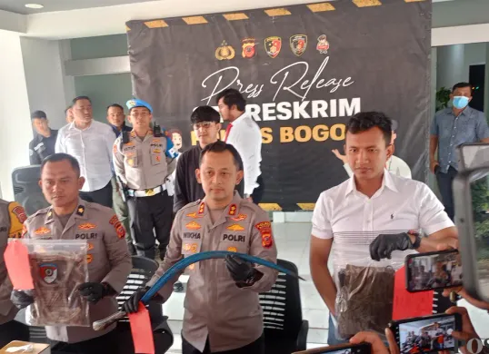 Kapolres Bogor AKBP Wikha Ardilestanto menunjukkan barang bukti celurit yang digunakan pelaku untuk menusuk korban hingga meninggal dunia, Kamis 21 Agustus 2025. (Sumber: Poskota/Giffar Rivana)