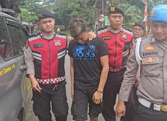 Polisi menggiring seorang remaja yang ditangkap karena menjual obat keras daftar G secara ilegal di kawasan Depok, Jawa Barat. (Sumber: Polsek Cimanggis)